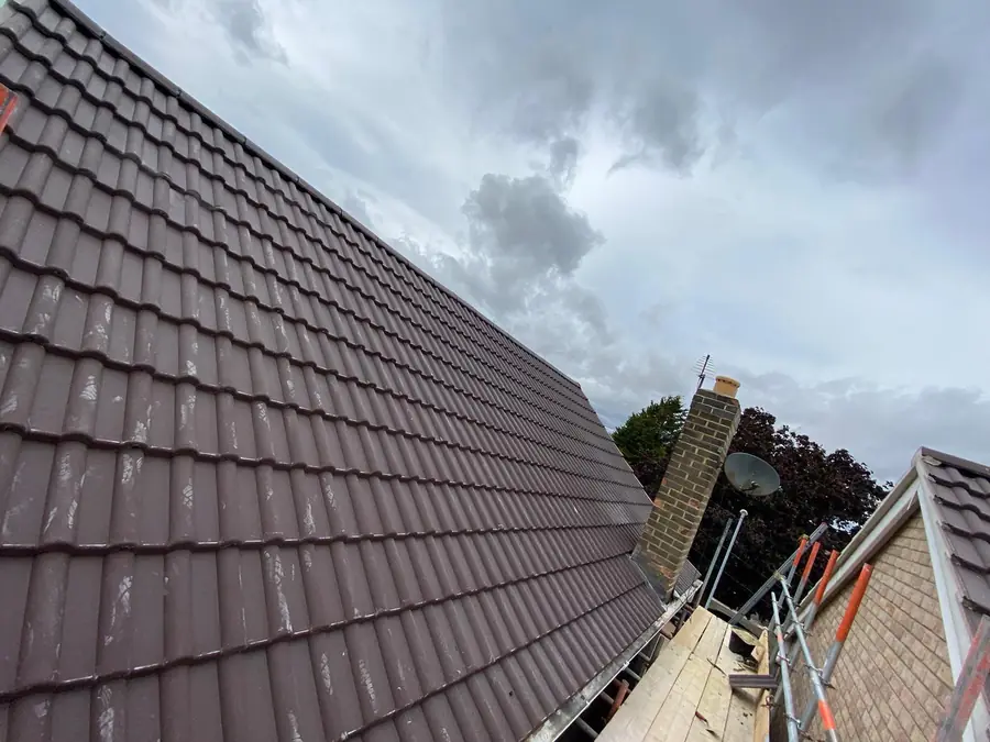 Finished brown tiled roof with chimney stack