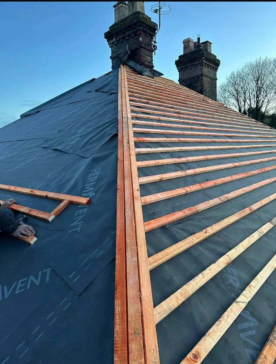 Dark membrane and battens laid up to two chimney stacks