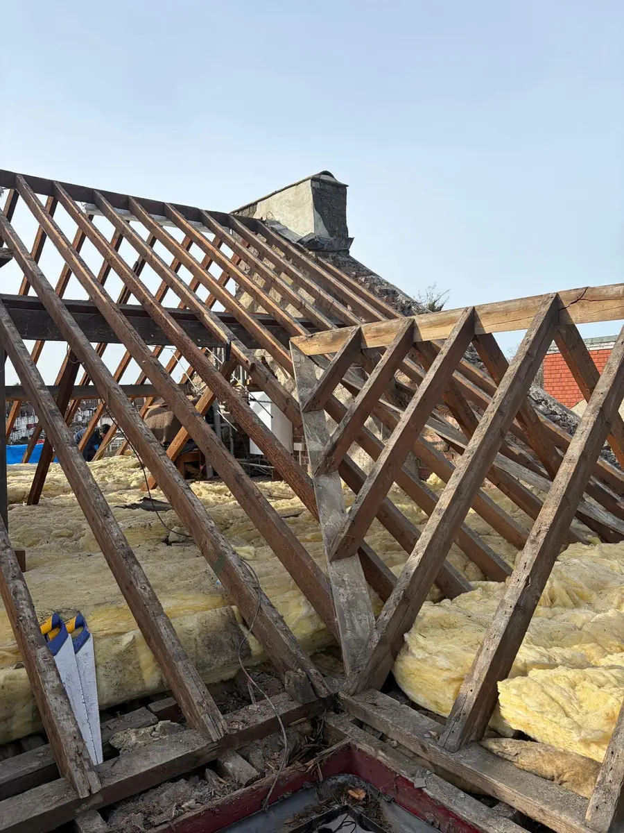 Exposed rafters and loft insulation during a full roof strip