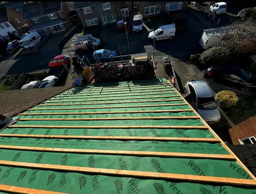Green membrane and battens on a roof above a residential street