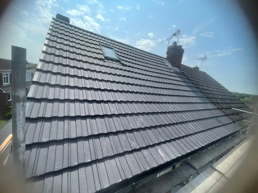 Finished grey tiled roof with ridge and chimney