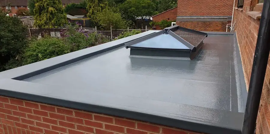 Finished grey GRP fibreglass flat roof with a flat rooflight on a rear extension