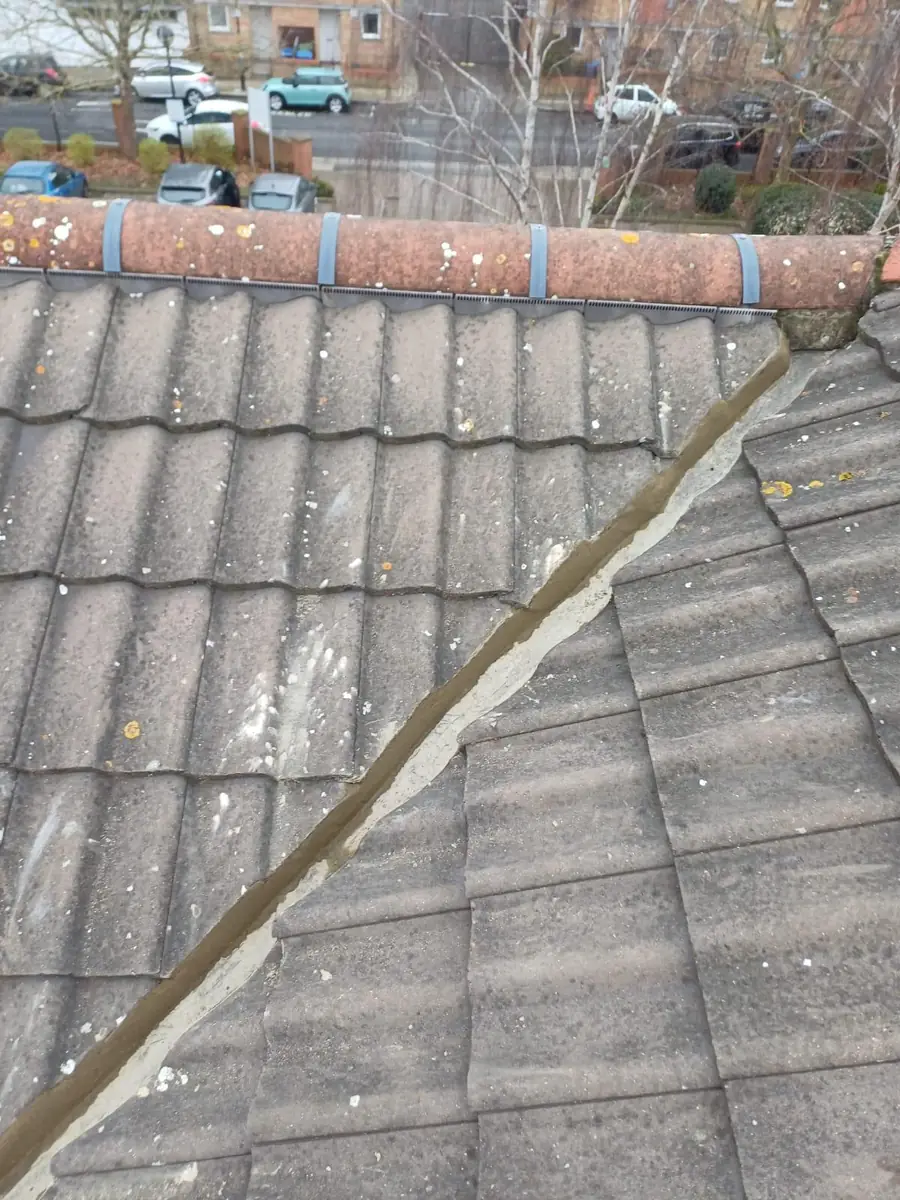 Old concrete tiled roof with a worn lead valley before repair