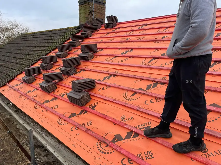 Orange membrane and battens up to a chimney, ready for tiles