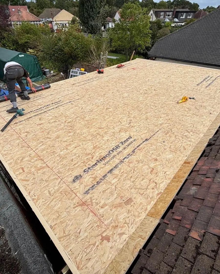 Roofer laying the OSB deck for a new flat roof
