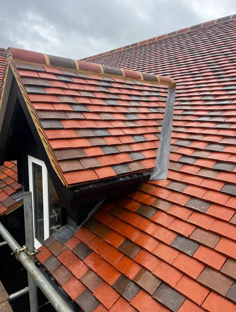Red plain tiles and lead detailing on a dormer