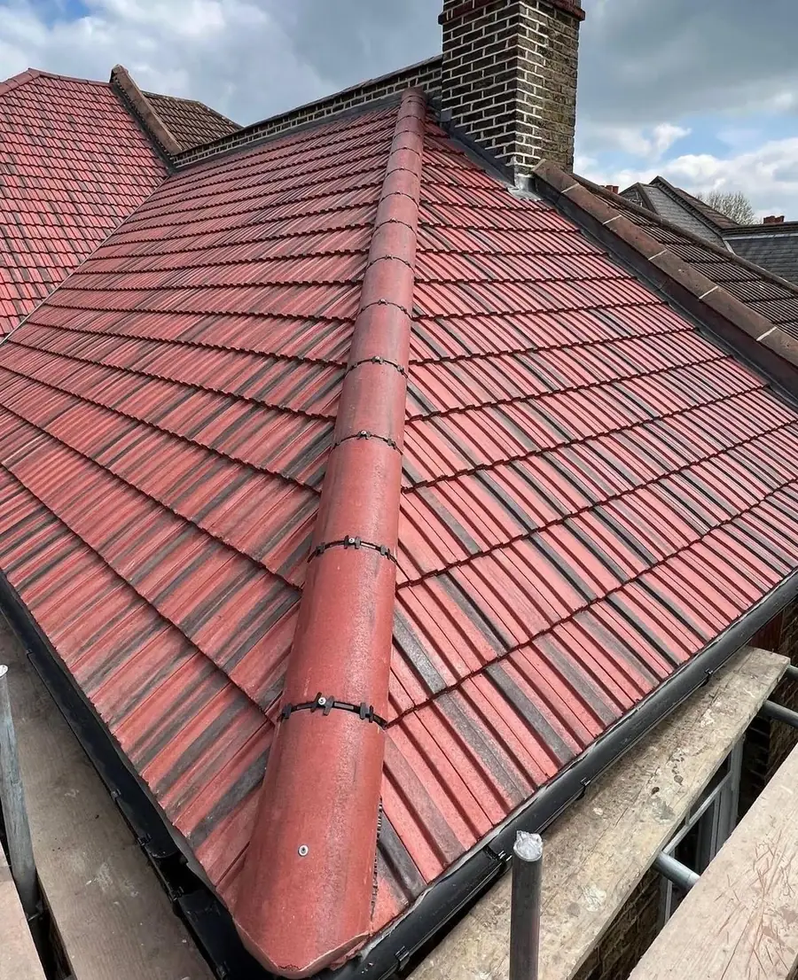 Red-brown tiled roof with new ridge and chimney