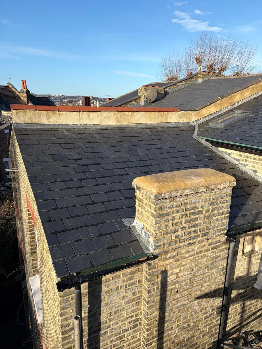 Natural slate roof with new lead flashing around a brick chimney